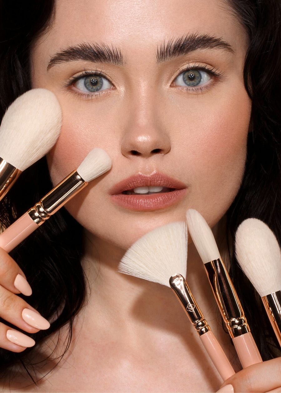 Modelka prezentująca pędzle do makijażu Annabelle Minerals na jasnym tle