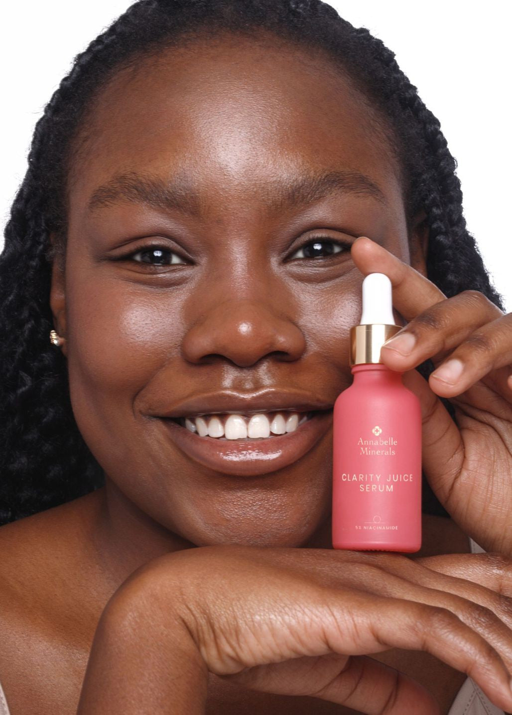 Uśmiechnięta modelka trzymająca serum Clarity Juice Annabelle Minerals z niacynamidem